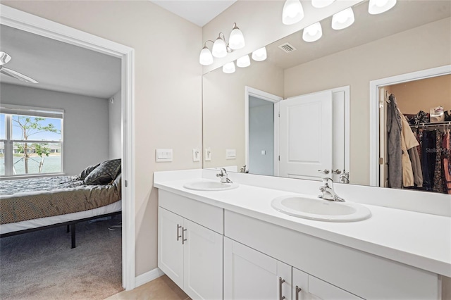 bathroom featuring a sink, a spacious closet, ensuite bath, and double vanity