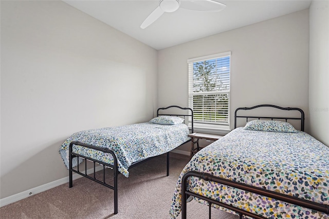 carpeted bedroom with ceiling fan and baseboards