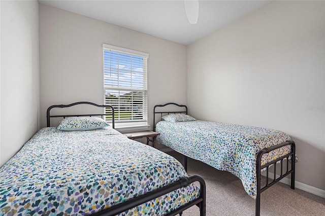 carpeted bedroom with ceiling fan and baseboards