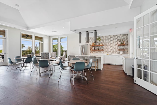 dining room featuring dark wood-type flooring, recessed lighting, and vaulted ceiling