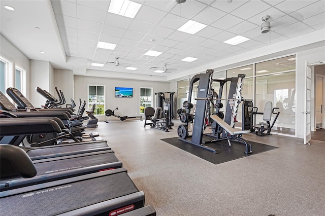 exercise room with a paneled ceiling and a ceiling fan