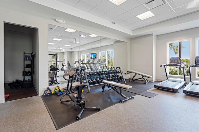 gym with a drop ceiling, visible vents, and baseboards