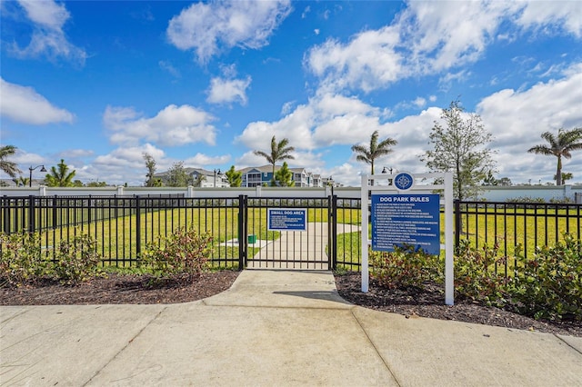 view of gate featuring fence and a lawn