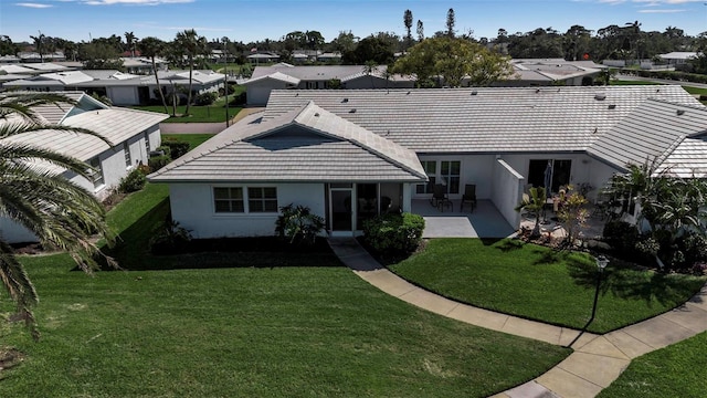 ranch-style house with stucco siding, a residential view, a patio, and a front yard