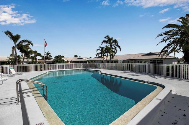 community pool with fence and a patio