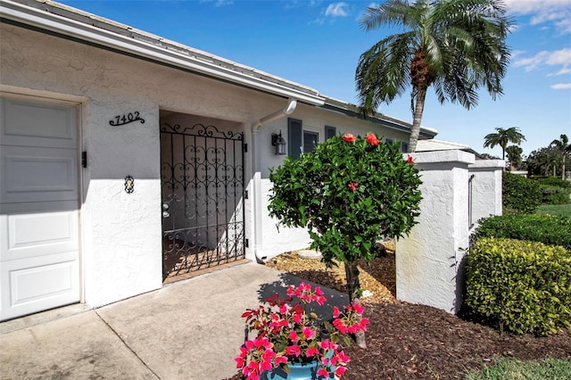 property entrance featuring an attached garage and stucco siding