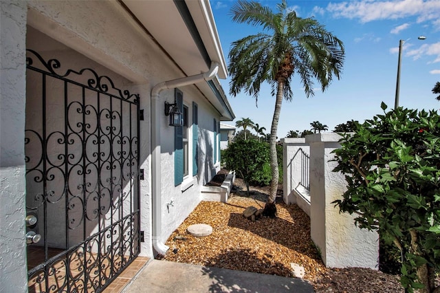 view of side of property featuring fence and stucco siding