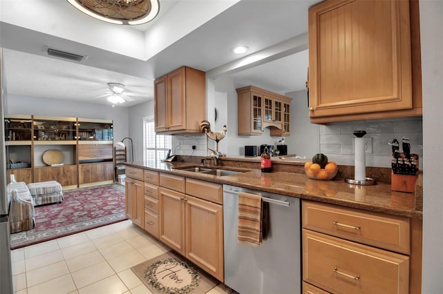 kitchen featuring visible vents, decorative backsplash, stainless steel dishwasher, a sink, and dark stone counters