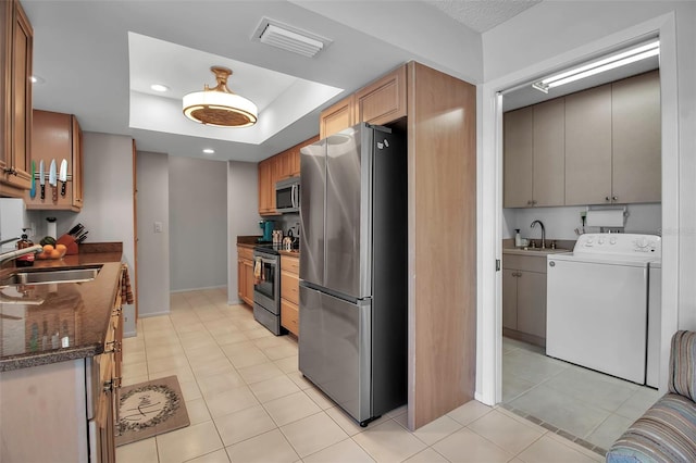 kitchen featuring a tray ceiling, visible vents, stainless steel appliances, and a sink