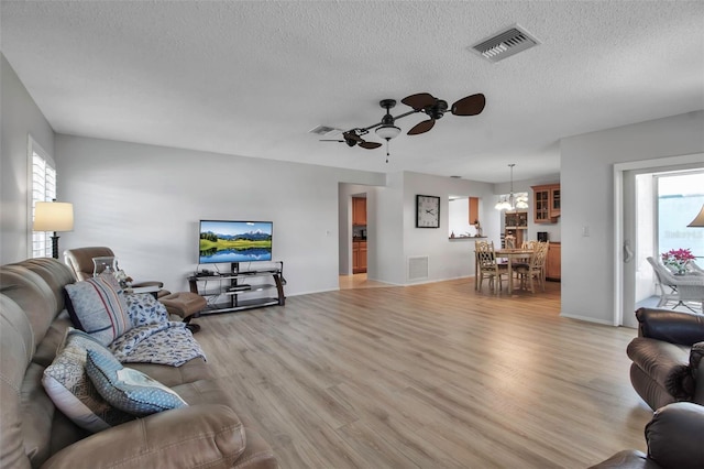 living room featuring light wood-type flooring, plenty of natural light, and visible vents