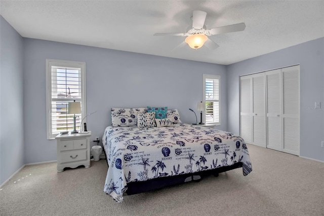 bedroom featuring baseboards, a ceiling fan, a textured ceiling, carpet floors, and a closet