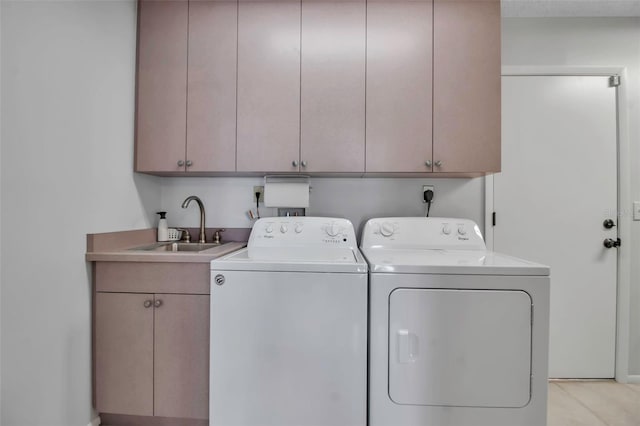 laundry room with cabinet space, washing machine and dryer, and a sink