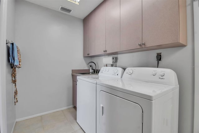 clothes washing area featuring cabinet space, baseboards, visible vents, washing machine and clothes dryer, and a sink