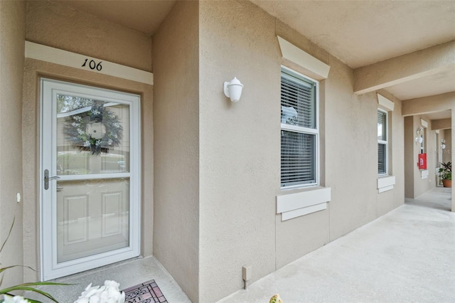 view of exterior entry with stucco siding