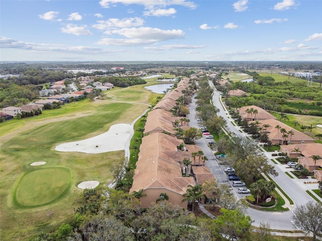 drone / aerial view featuring golf course view and a water view