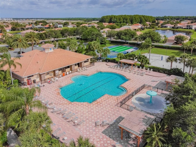 pool with a patio, a water view, and fence