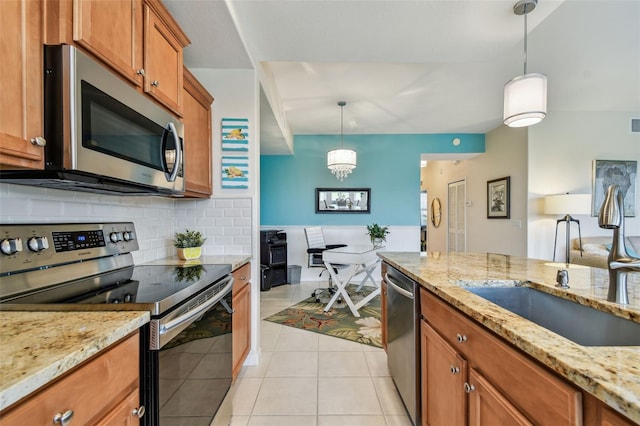 kitchen with decorative backsplash, brown cabinetry, appliances with stainless steel finishes, a sink, and light tile patterned flooring