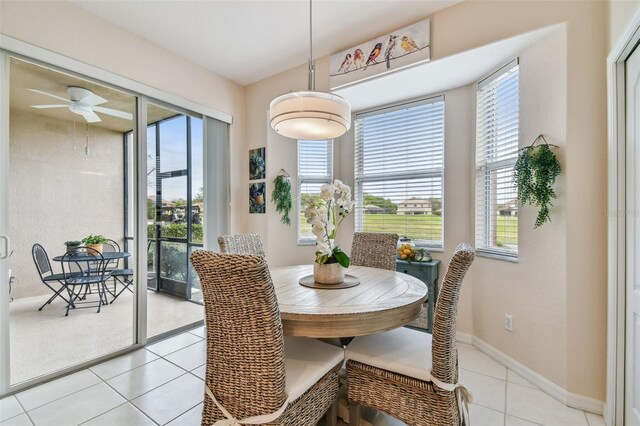 dining area with ceiling fan, baseboards, and light tile patterned flooring