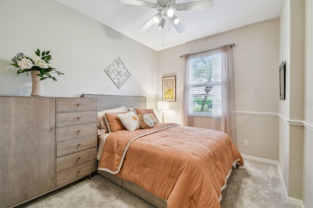 bedroom with ceiling fan, baseboards, and light colored carpet