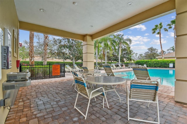 view of patio featuring fence and a community pool