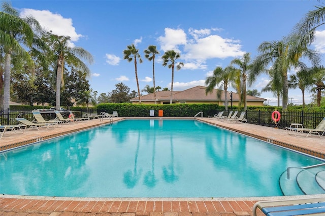 community pool featuring a patio area and fence