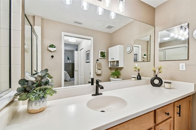 bathroom featuring a shower with door, ensuite bath, visible vents, and vanity