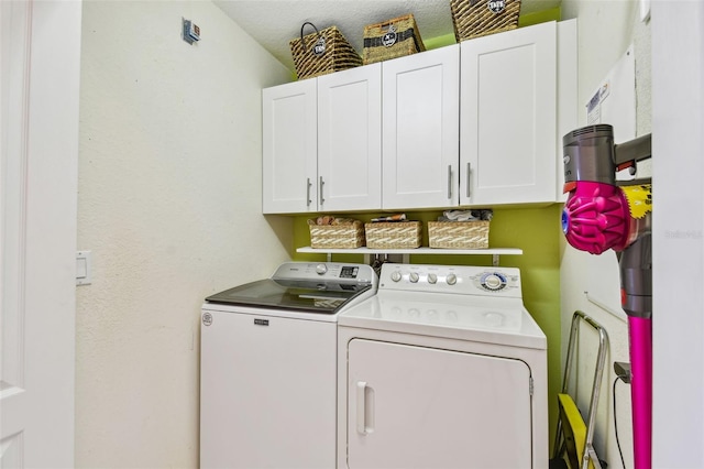 clothes washing area featuring washing machine and dryer and cabinet space