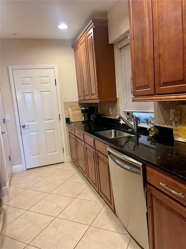 kitchen featuring light tile patterned floors, decorative backsplash, a sink, dark stone counters, and dishwasher