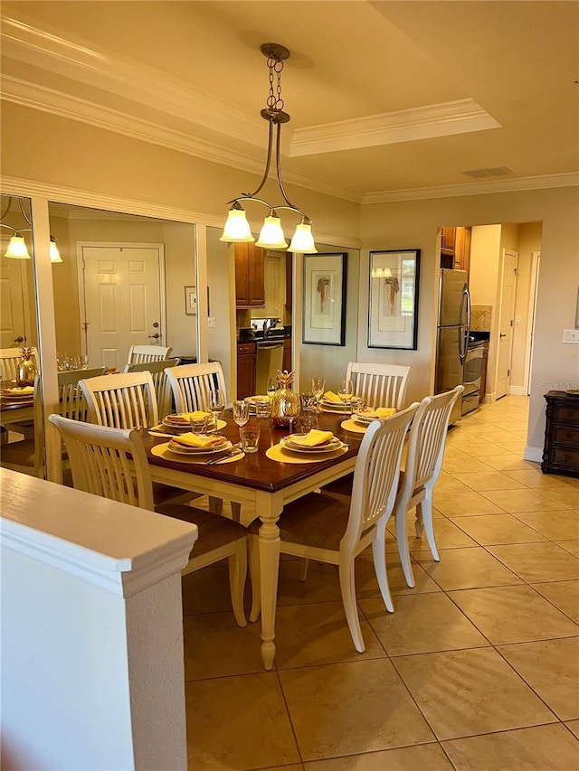 dining space with ornamental molding, a tray ceiling, and light tile patterned flooring