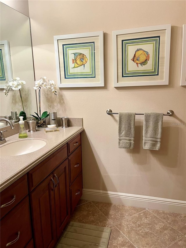 bathroom featuring tile patterned flooring, baseboards, and vanity