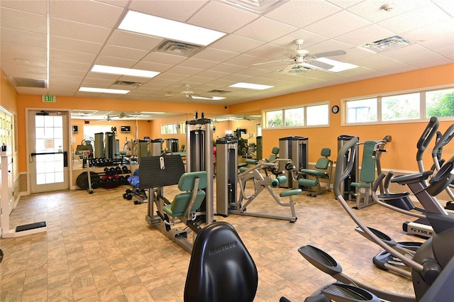 exercise room featuring ceiling fan, a paneled ceiling, and visible vents