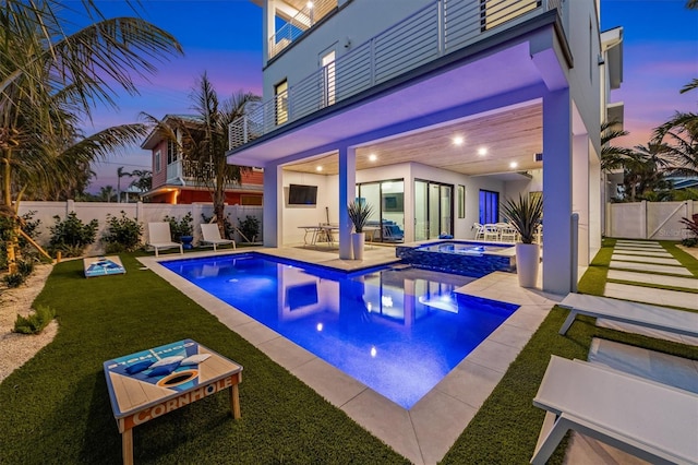 view of pool with a patio, a lawn, a fenced backyard, and a pool with connected hot tub