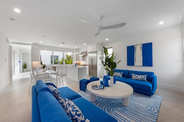 living room with baseboards, a ceiling fan, and recessed lighting