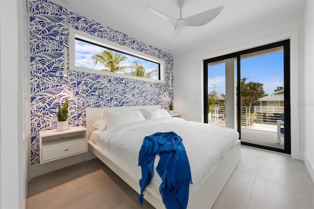 bedroom with wallpapered walls, ceiling fan, an accent wall, and access to exterior