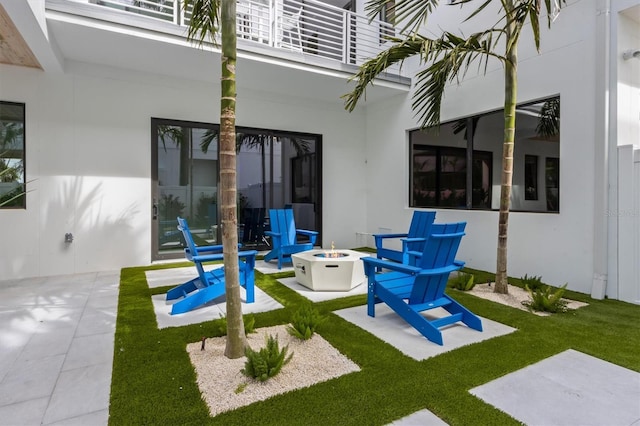 view of patio / terrace with a balcony and an outdoor fire pit