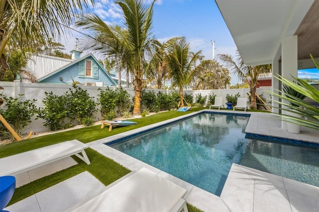 view of swimming pool with a fenced in pool, a fenced backyard, and a yard