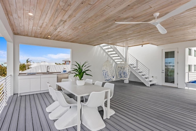 deck with ceiling fan, stairway, a sink, and outdoor dining space