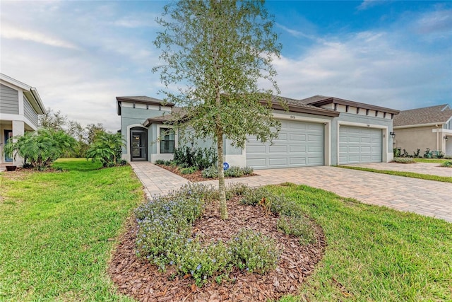 view of front of house with a garage, a front yard, decorative driveway, and stucco siding