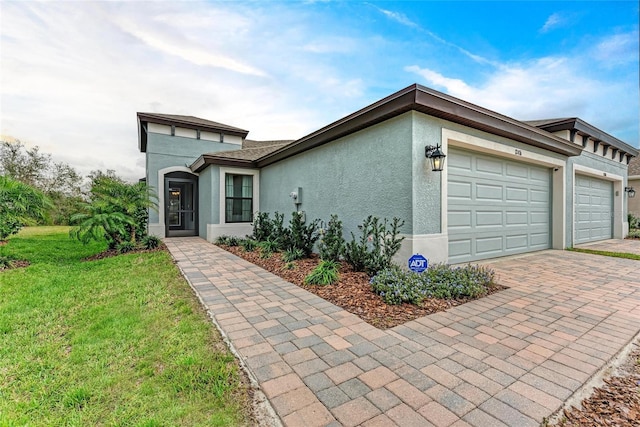 view of front of house with a front lawn, decorative driveway, an attached garage, and stucco siding