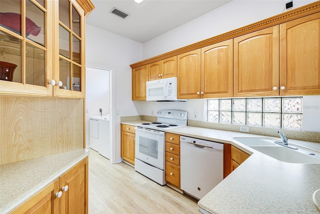 kitchen with white appliances, visible vents, glass insert cabinets, light countertops, and washer and dryer