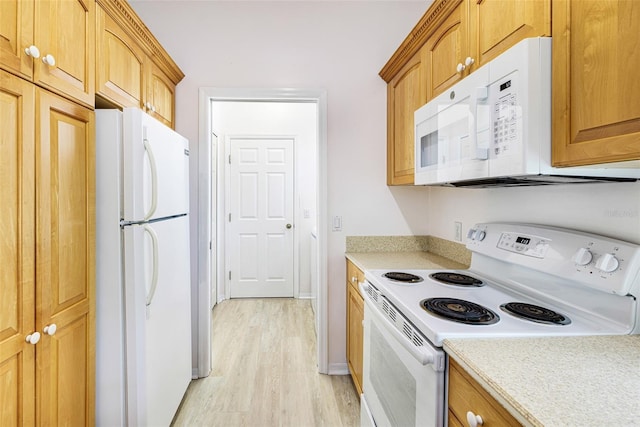 kitchen with white appliances, light countertops, light wood-style floors, and brown cabinetry