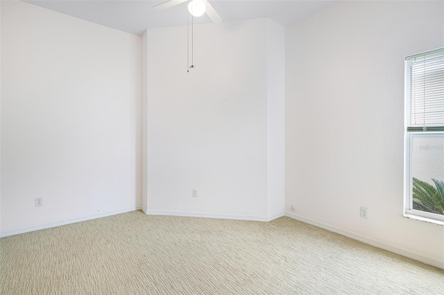 unfurnished room featuring light carpet, a ceiling fan, and baseboards