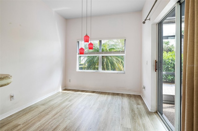 unfurnished dining area with light wood-style floors and baseboards