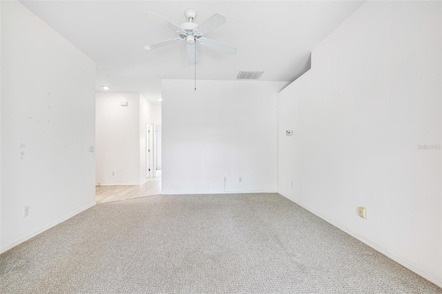 unfurnished room featuring baseboards, a ceiling fan, visible vents, and light colored carpet