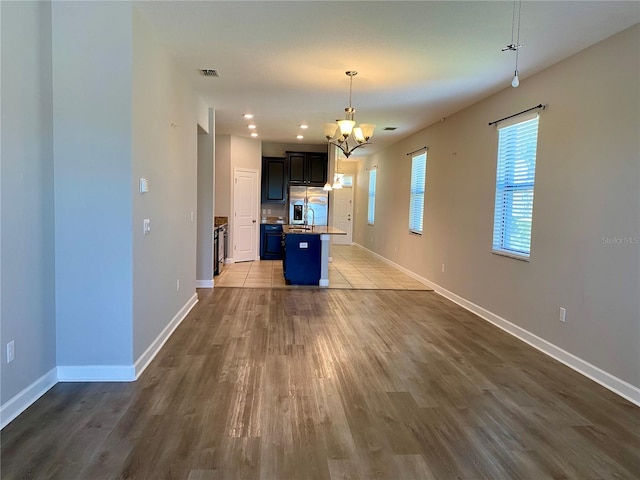 kitchen featuring dark wood-style floors, stainless steel fridge, visible vents, and baseboards