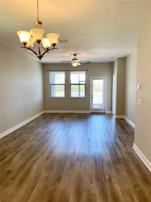 unfurnished room with a textured ceiling, dark wood-type flooring, ceiling fan with notable chandelier, and baseboards