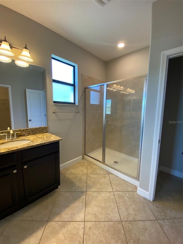 bathroom featuring baseboards, a stall shower, vanity, and tile patterned floors