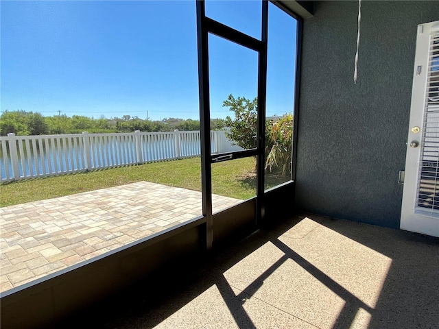 unfurnished sunroom featuring a water view