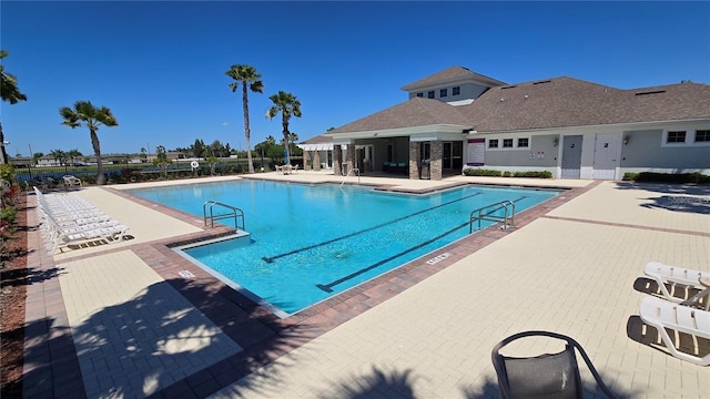 pool with a patio and fence