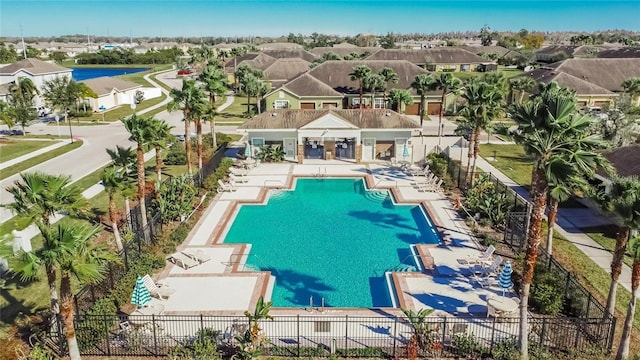 view of swimming pool featuring a patio area, a residential view, and fence